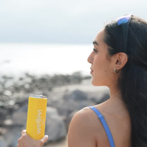 Mujer tomando Wellen en la playa