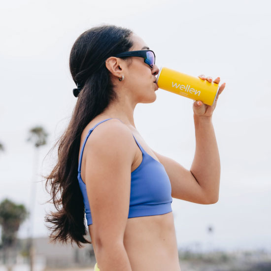 Deportista bebiedo Wellen bebida refrescante